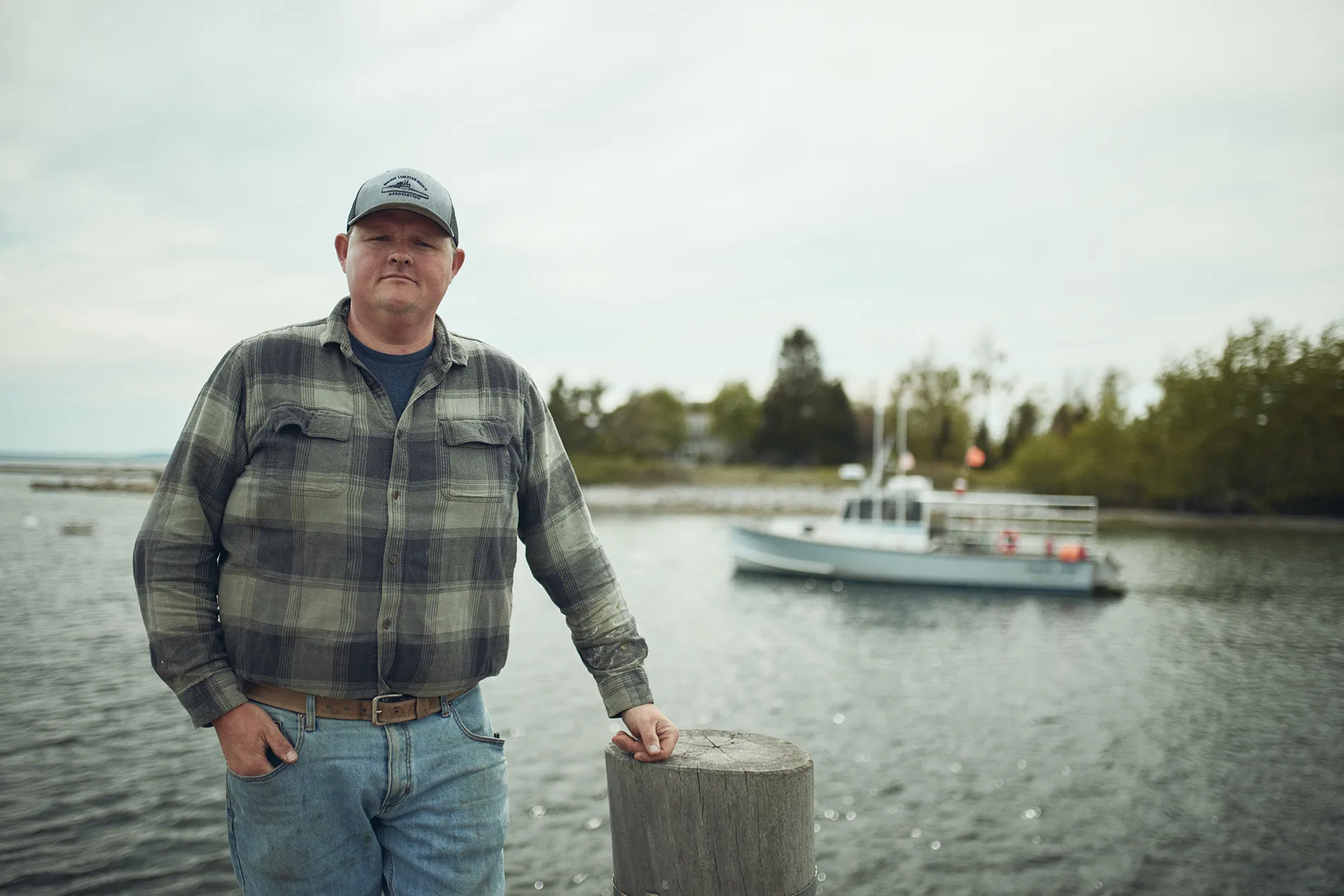 fisherman leaning on a dock post
